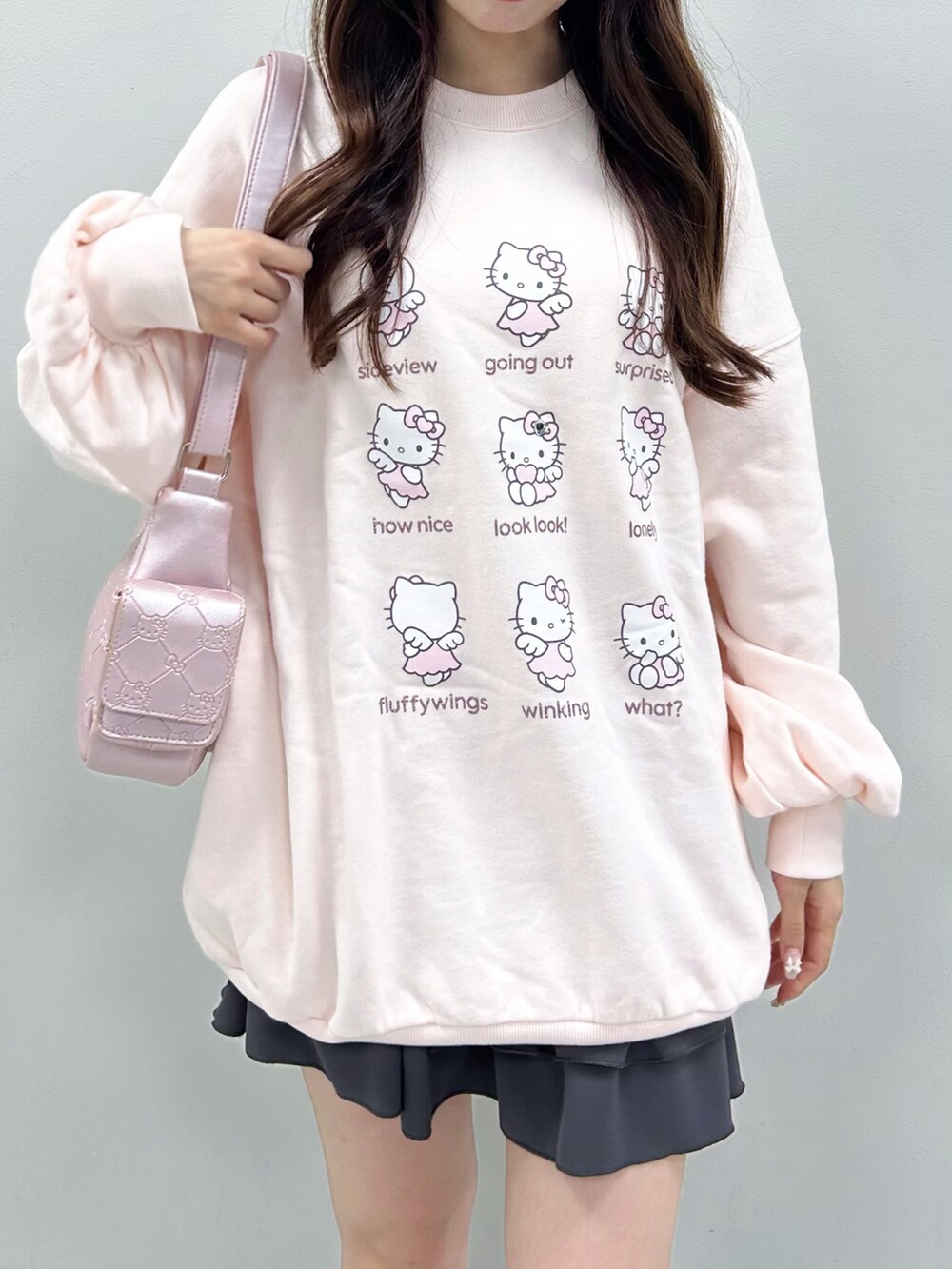 ピンク系のトップス、ピンク系のショルダーバッグ、グレー系のスカートを着用したレディースの秋コーディネートの4枚目の写真