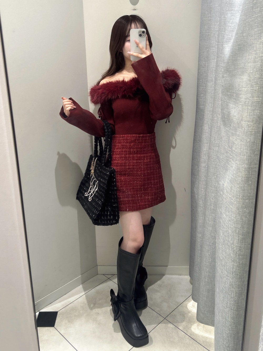 ブラック系のトートバッグ、レッド系のトップス、レッド系のスカートを着用したレディースの秋コーディネートの4枚目の写真