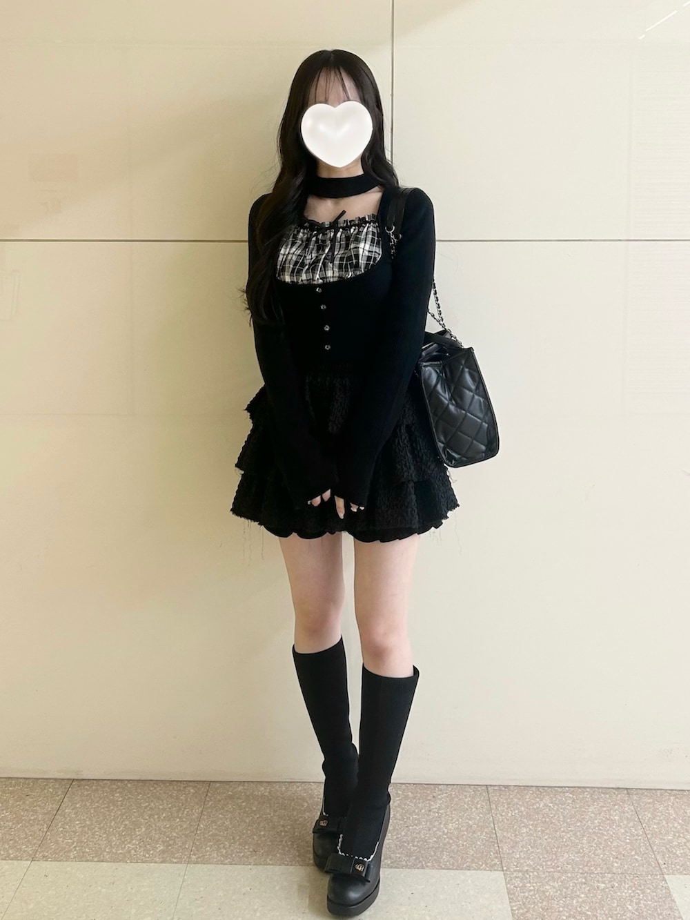 ブラック系のスカート、ブラック系のトートバッグ、ブラック系のブーツを着用したレディースの春コーディネートの7枚目の写真