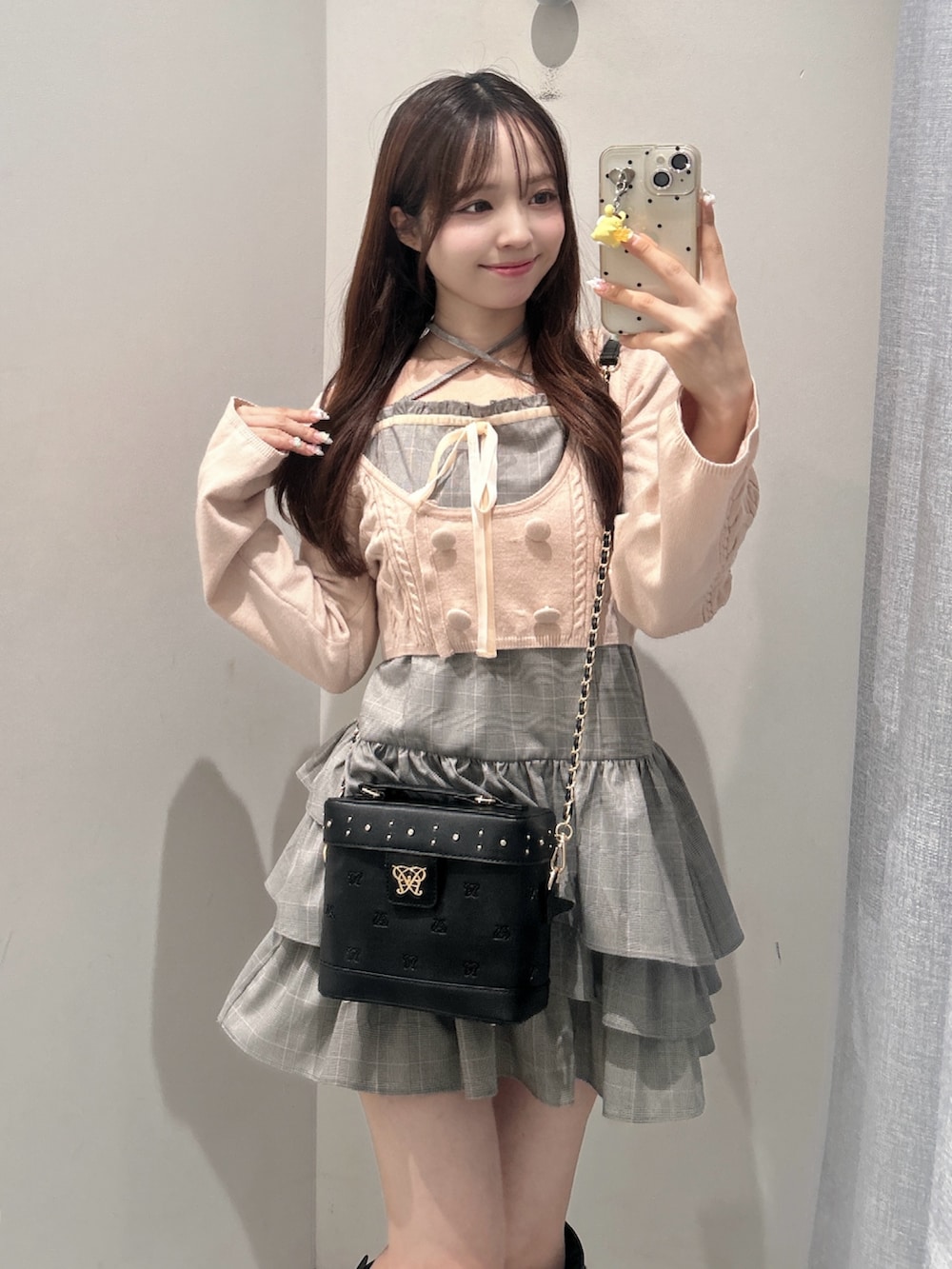 グレー系のワンピース、ブラック系のショルダーバッグ、ブラック系のブーツを着用したレディースの秋コーディネートの2枚目の写真
