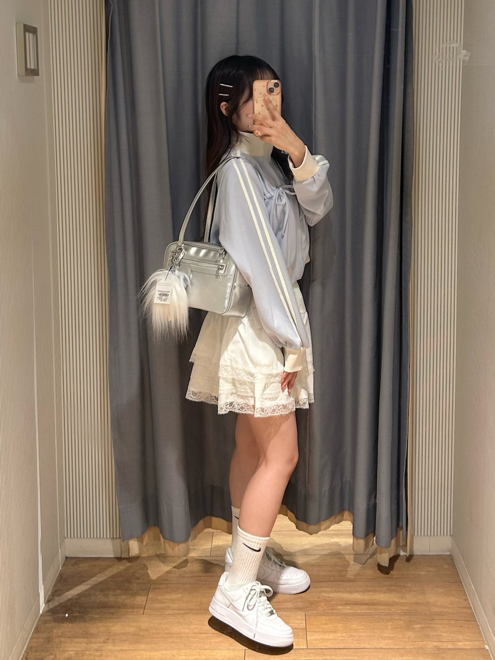 ホワイト系のスカート、ブラック系のスウェット、ホワイト系のスニーカーを着用したレディースの秋コーディネートの2枚目の写真