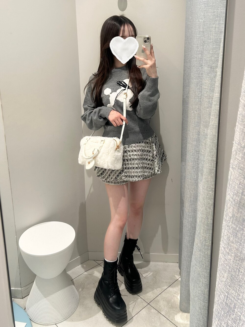 グレー系のニット/セーター、ブラック系のスカート、ホワイト系のショルダーバッグを着用したレディースの秋コーディネートの3枚目の写真