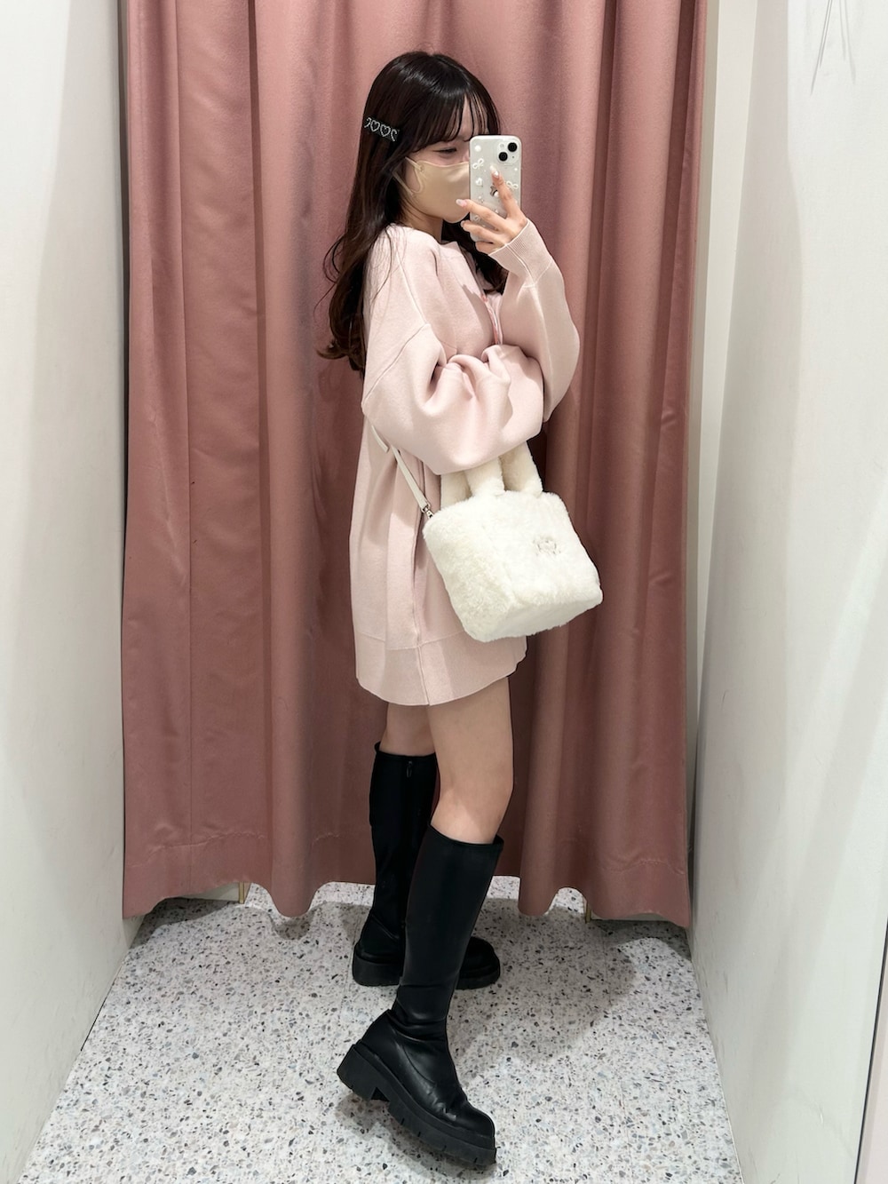 ピンク系のニット/セーター、ホワイト系のトートバッグ、ブラック系のブーツを着用したレディースの冬コーディネートの3枚目の写真