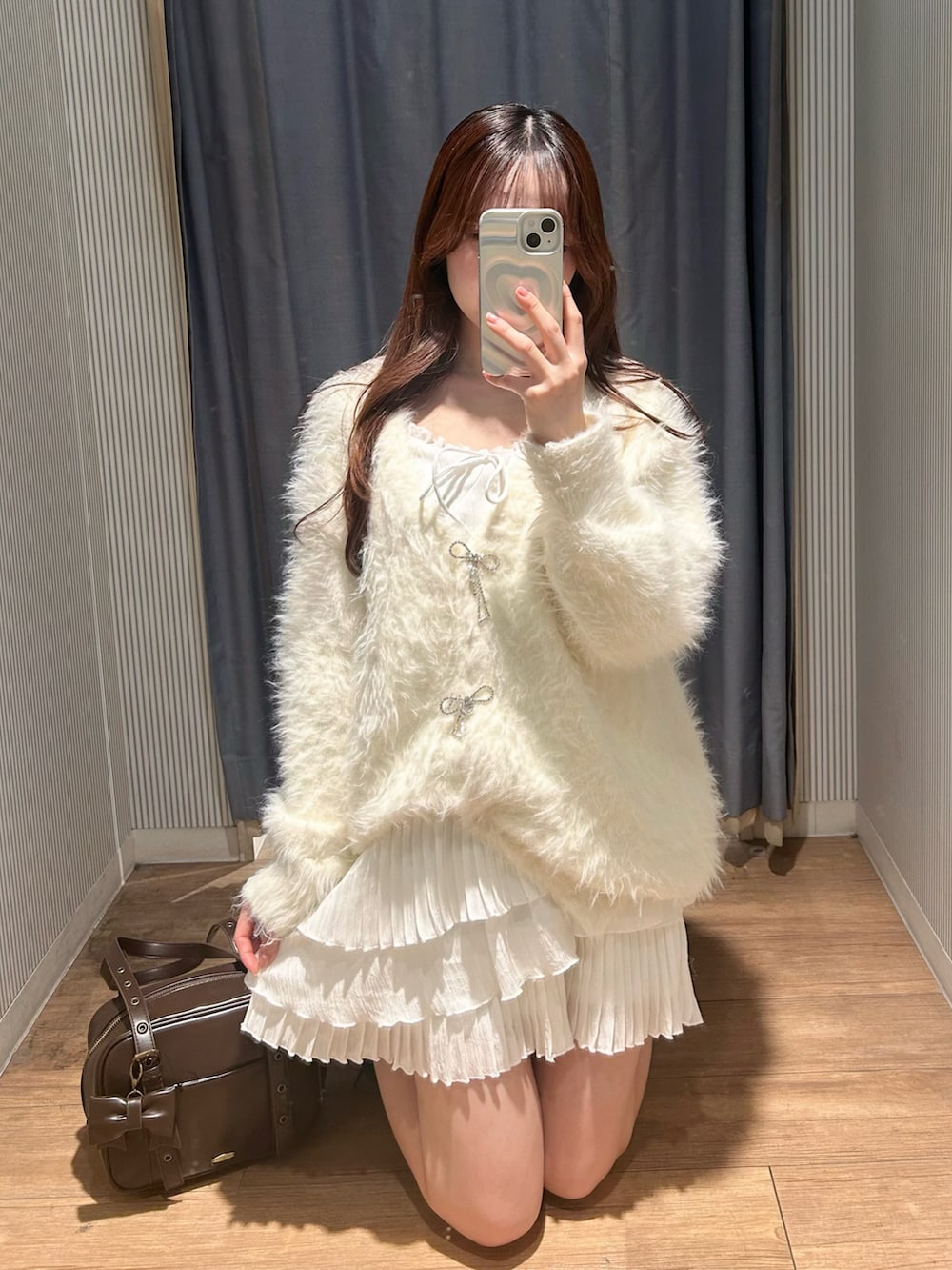 ブラウン系のショルダーバッグ、ホワイト系のワンピース、ホワイト系のカーディガン/ボレロを着用したレディースの冬コーディネートの4枚目の写真