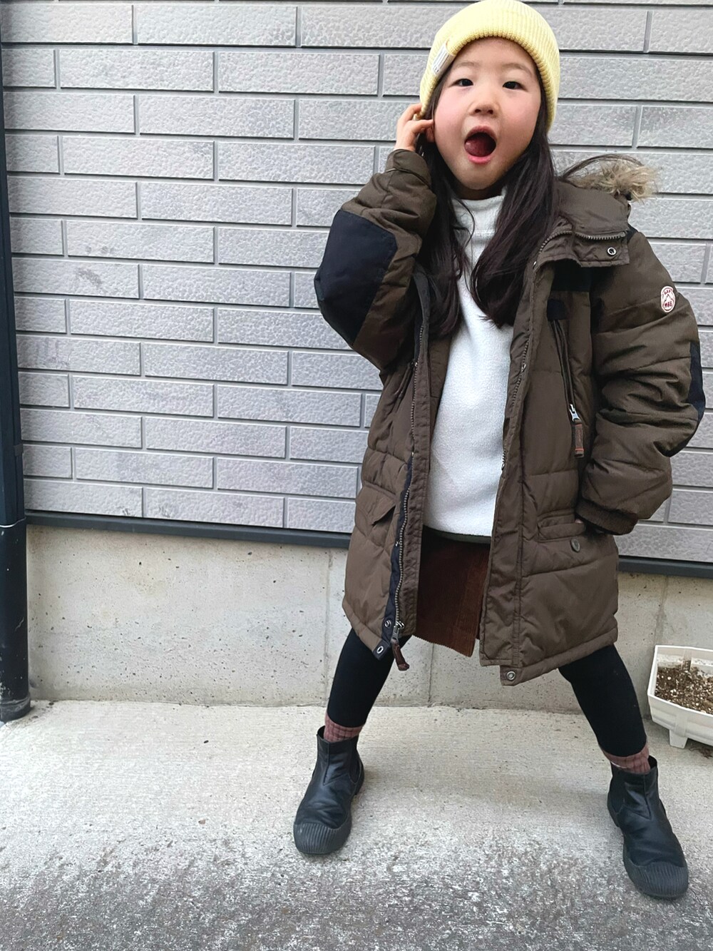 ホワイト系のトップス、グリーン系のMA-1、ブラウン系のその他パンツを着用したキッズの冬コーディネートの2枚目の写真