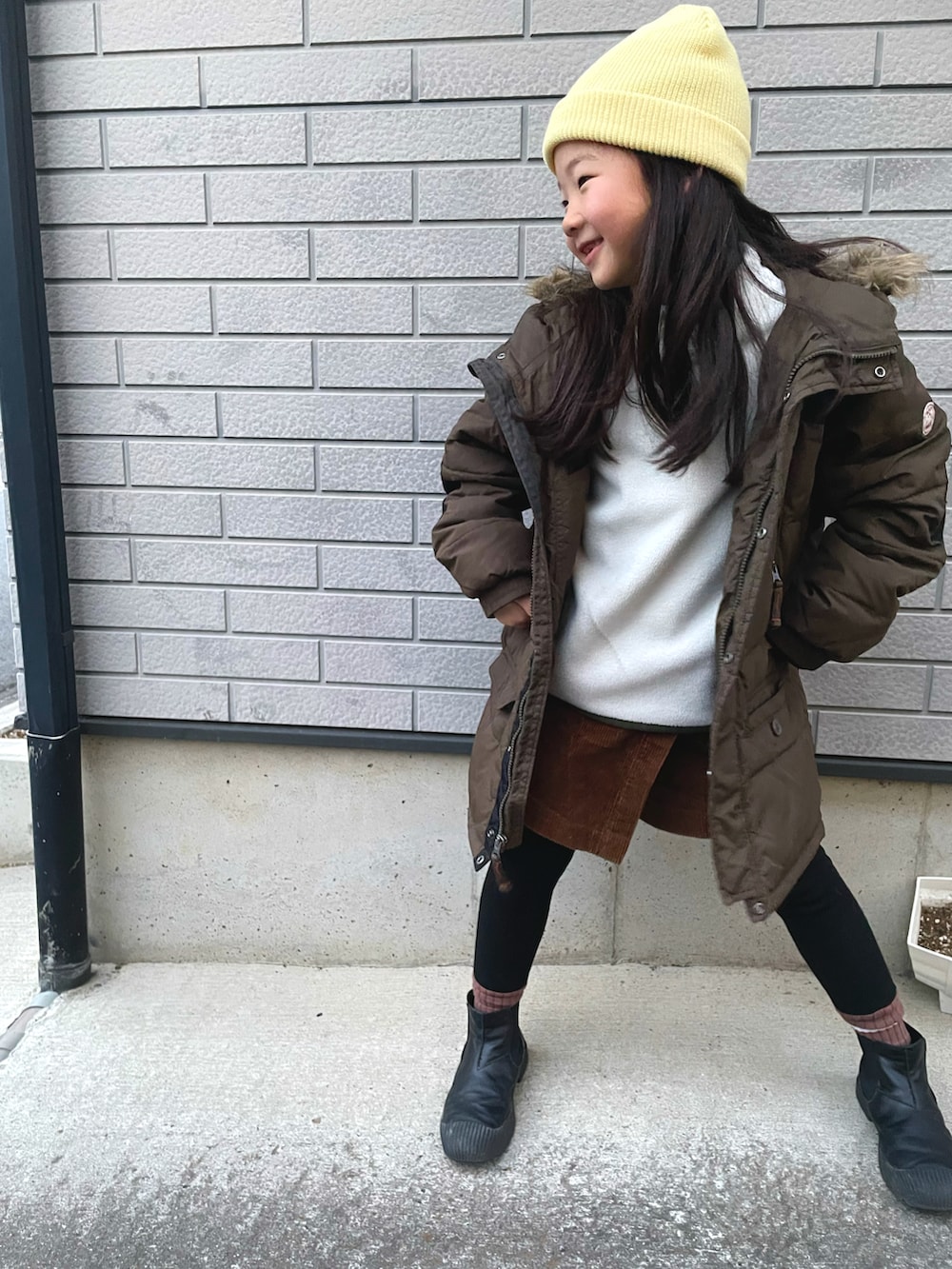 ホワイト系のトップス、グリーン系のMA-1、ブラウン系のその他パンツを着用したキッズの冬コーディネートの3枚目の写真