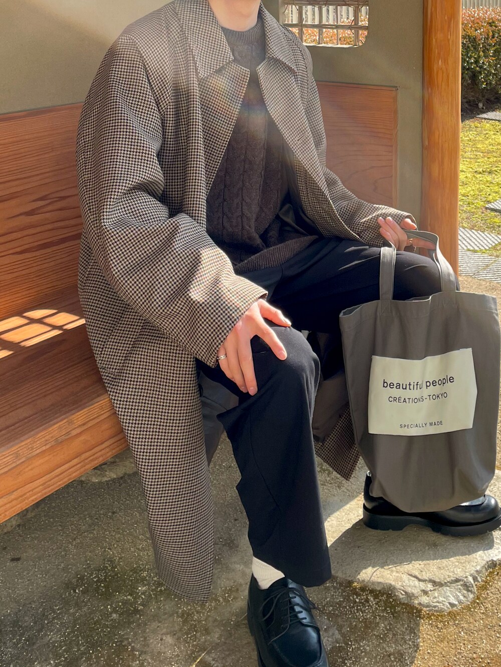 ブラック系のドレスシューズ、グレー系のトートバッグ、ブラック系のスラックスを着用したメンズの冬コーディネートの2枚目の写真
