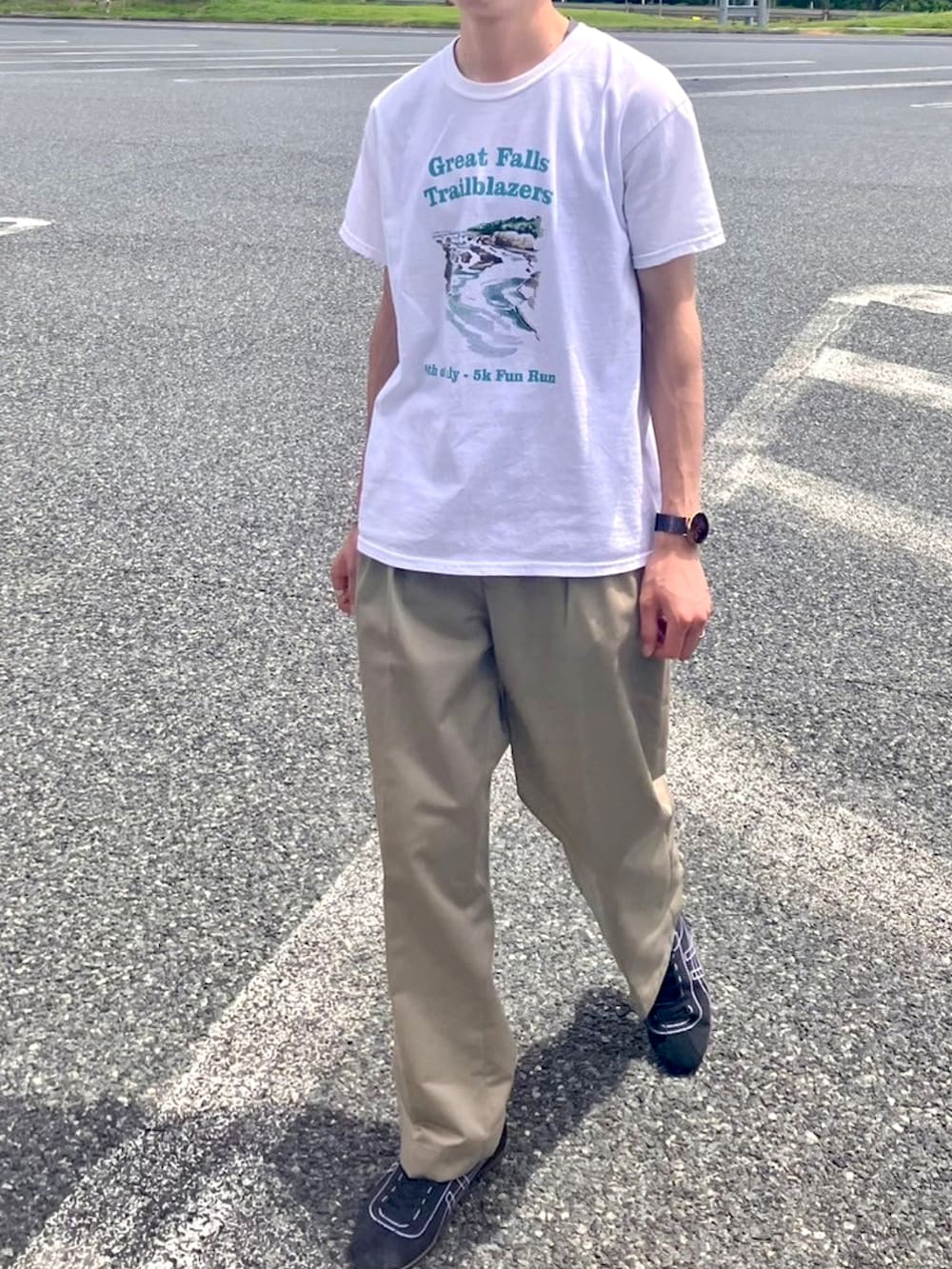 ホワイト系のTシャツ/カットソー、ベージュ系のスラックス、ホワイト系のスニーカーを着用したメンズの夏コーディネートの2枚目の写真