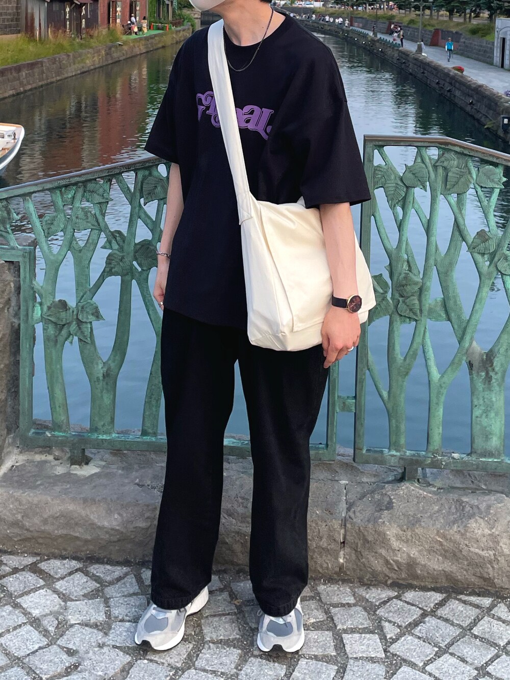 ブラック系のデニムパンツ、グレー系のスニーカー、ホワイト系のショルダーバッグを着用したメンズの夏コーディネートの2枚目の写真