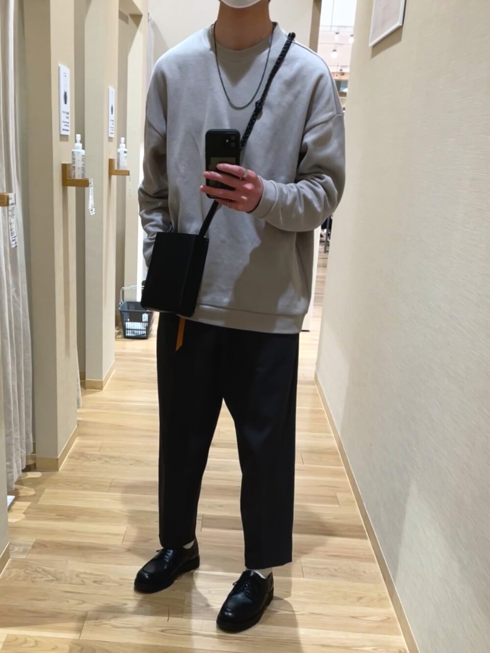 ブラック系のショルダーバッグ、グレー系のスラックス、ブラック系のドレスシューズを着用したメンズの春コーディネートの3枚目の写真