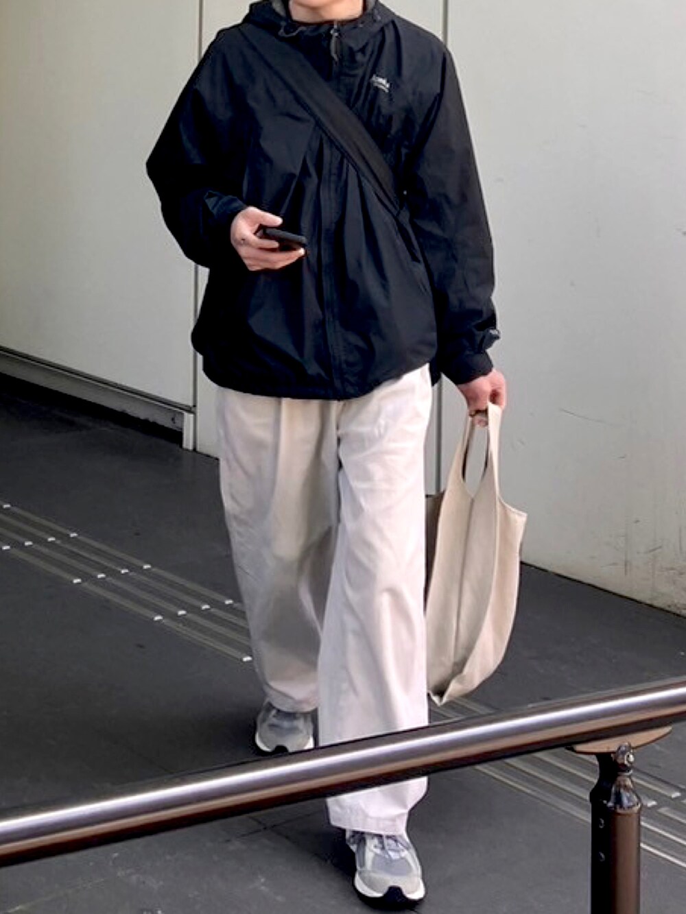 ブラック系のTシャツ/カットソー、ホワイト系のチノパンツ、グレー系のバッグを着用したメンズの春コーディネートの3枚目の写真