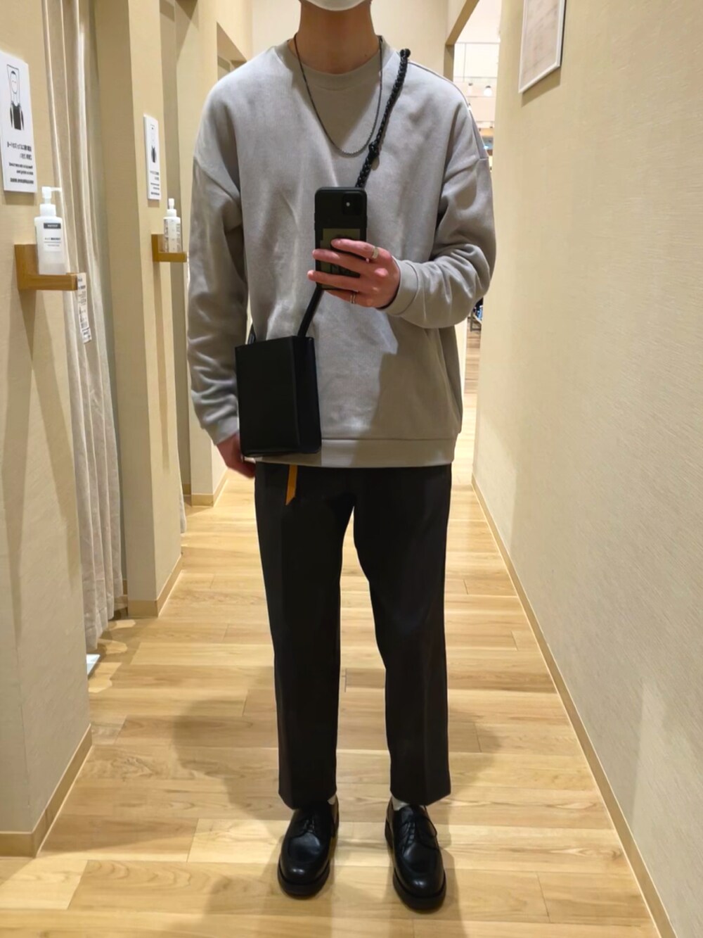 ブラック系のショルダーバッグ、グレー系のスラックス、ブラック系のドレスシューズを着用したメンズの春コーディネートの2枚目の写真