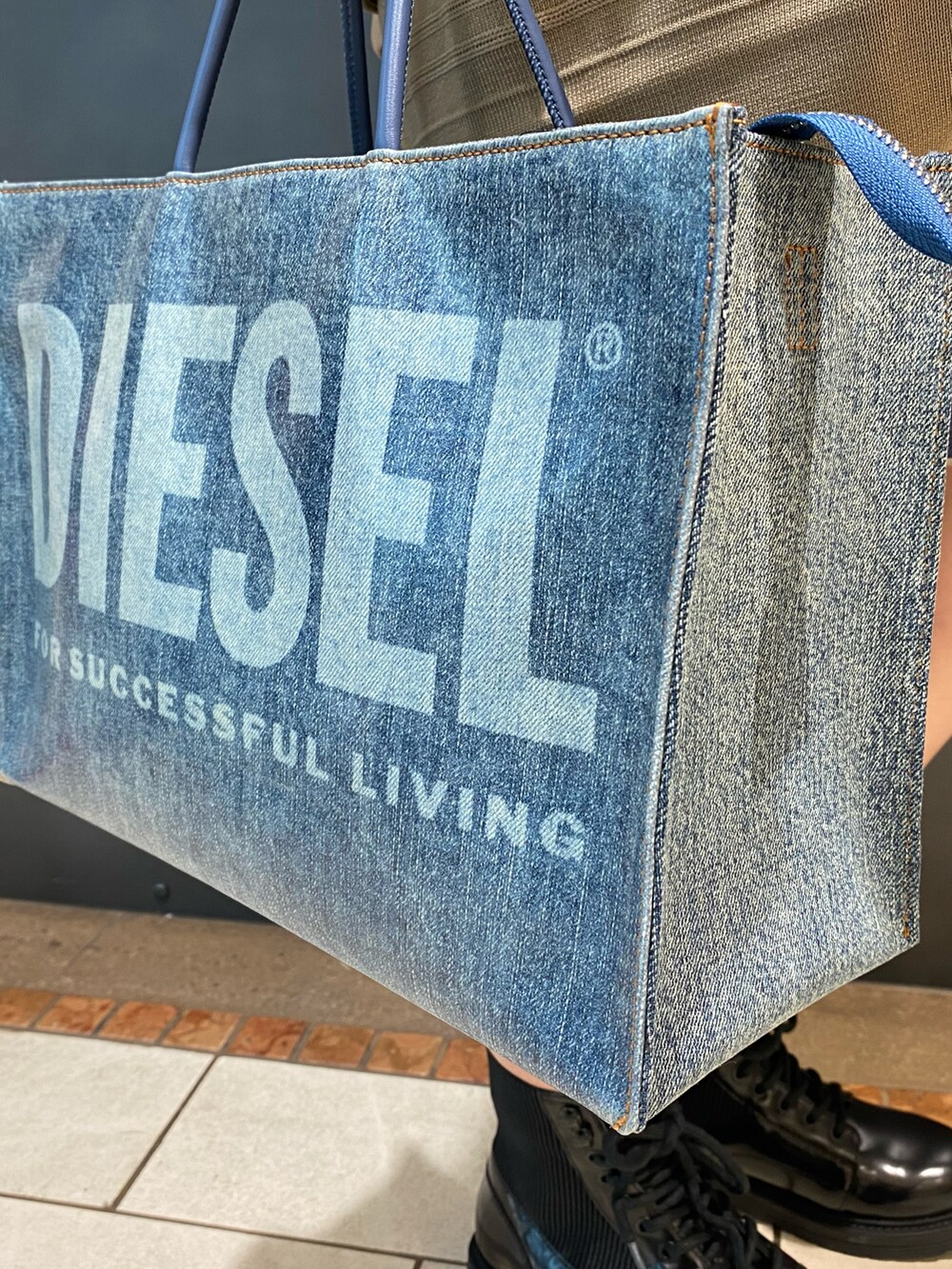 ベージュ系のワンピース、ブルー系のバッグ、ブラック系のブーツを着用したレディースの秋コーディネートの2枚目の写真