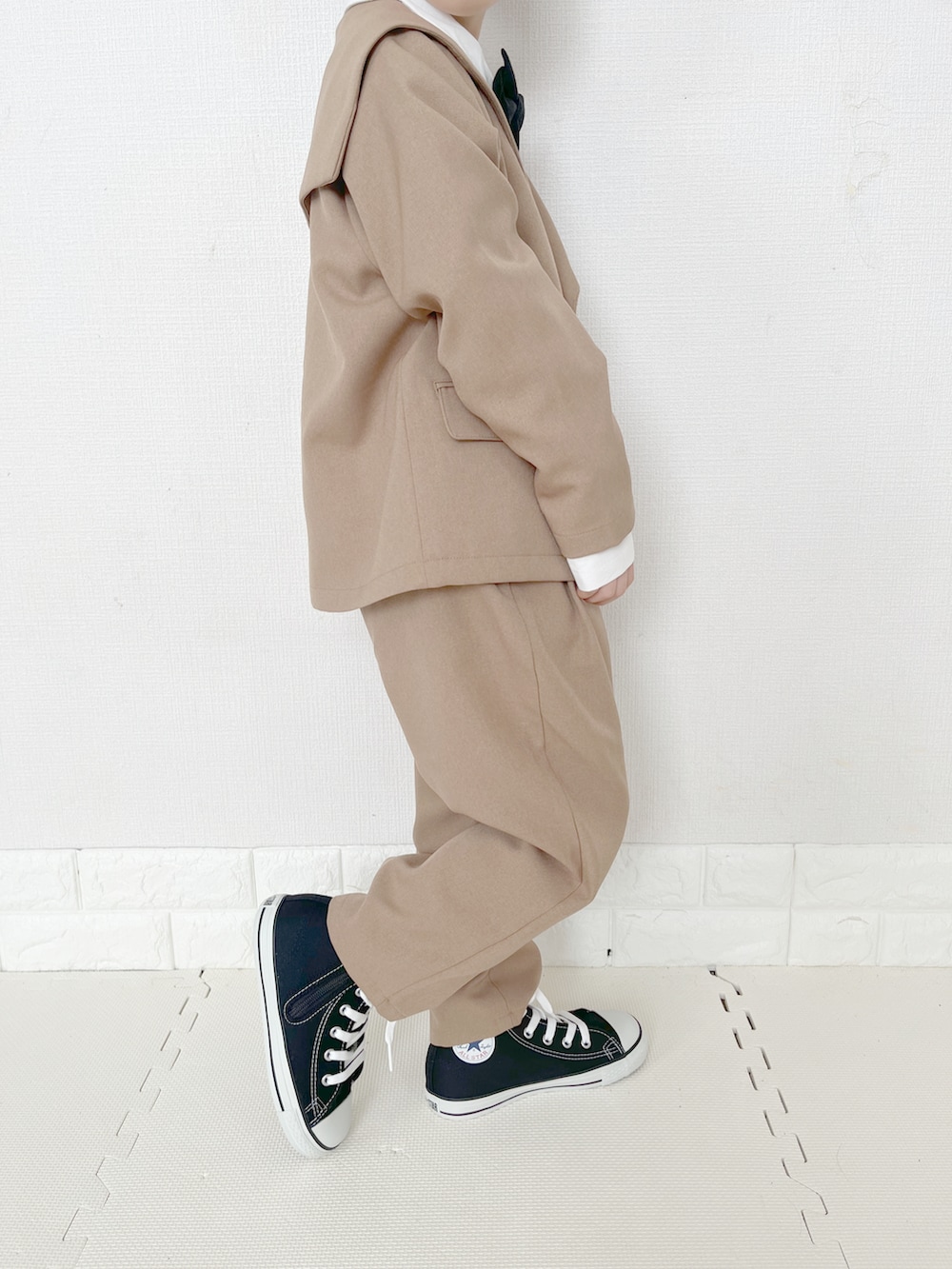 ブラウン系のテーラードジャケット、ブラウン系のその他パンツ、ホワイト系のシャツ/ブラウスを着用したキッズの春コーディネートの2枚目の写真