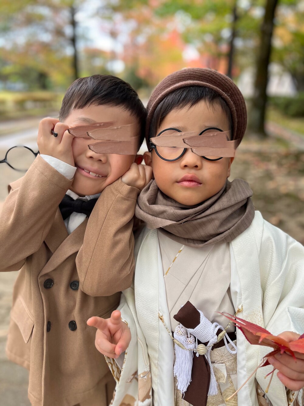 ブラウン系のテーラードジャケット、ブラウン系のその他パンツ、ブラック系の蝶ネクタイを着用したキッズの秋コーディネートの3枚目の写真