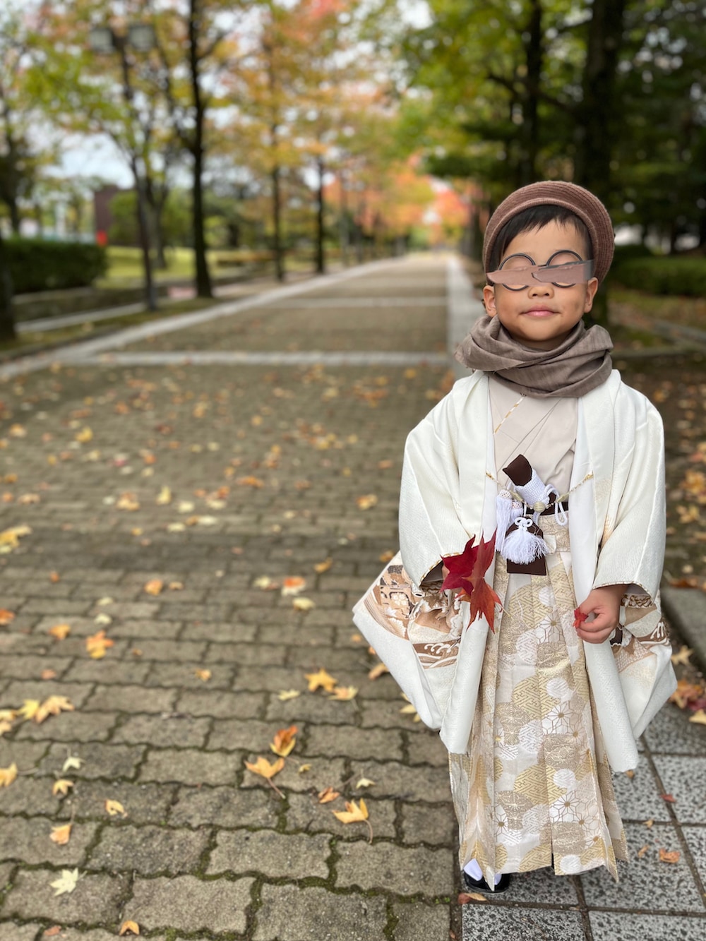 ブラウン系のテーラードジャケット、ブラウン系のその他パンツ、ブラック系の蝶ネクタイを着用したキッズの秋コーディネートの4枚目の写真