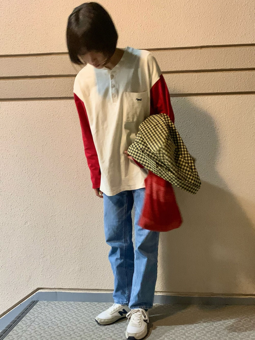 イエロー系のテーラードジャケット、レッド系のトートバッグ、ブルー系のデニムパンツを着用したレディースの秋コーディネートの2枚目の写真