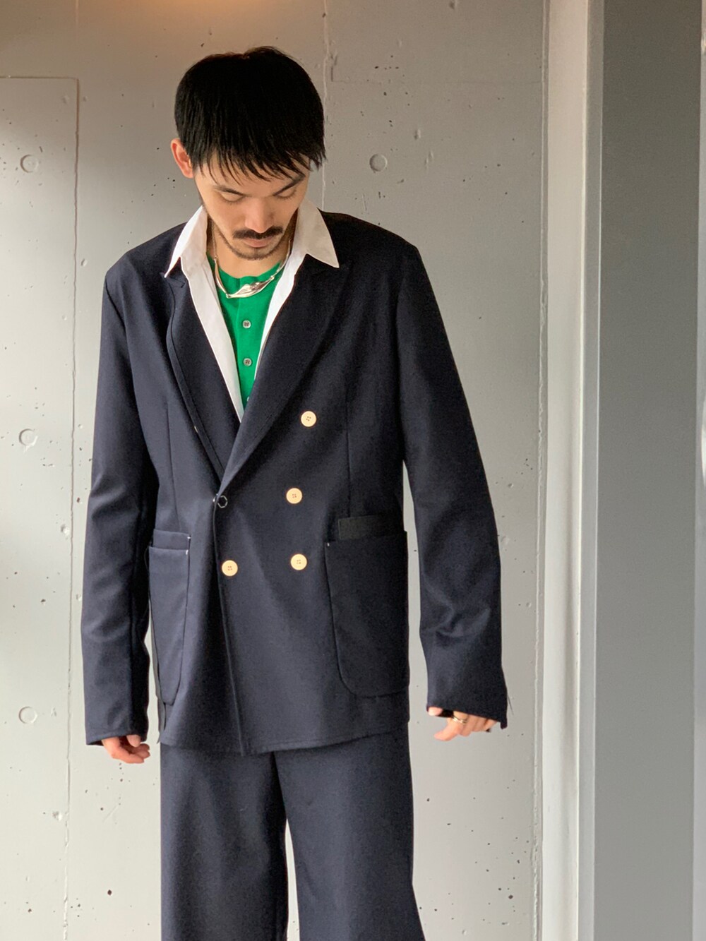 グリーン系のカーディガン/ボレロ、ブルー系のテーラードジャケット、ブルー系のスラックスを着用したメンズの冬コーディネートの2枚目の写真
