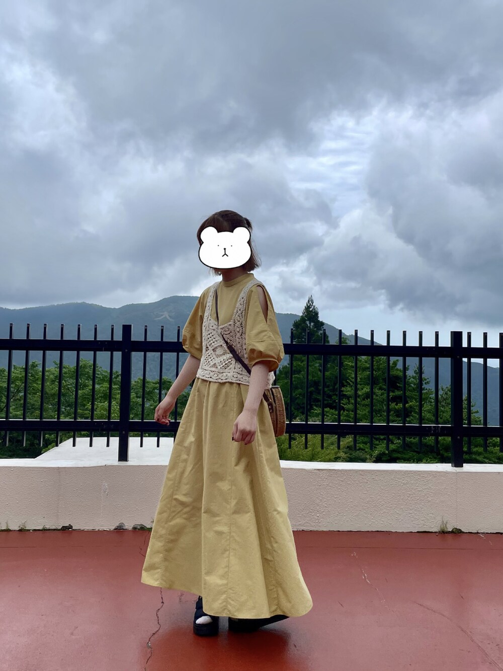 イエロー系のワンピース、ベージュ系のその他トップス、ブラック系のサンダルを着用したレディースの夏コーディネートの3枚目の写真