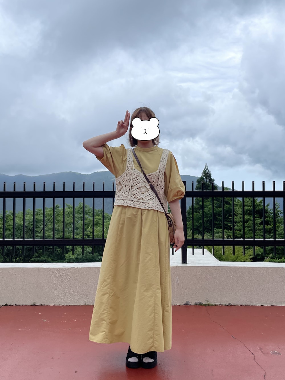 イエロー系のワンピース、ベージュ系のその他トップス、ブラック系のサンダルを着用したレディースの夏コーディネートの2枚目の写真