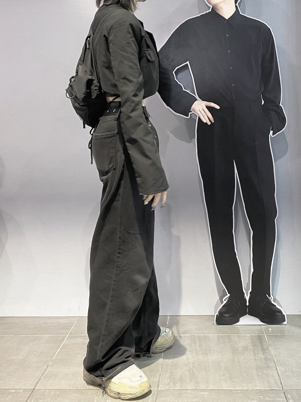 ブラック系のデニムパンツ、ホワイト系のスニーカー、ブラック系のジャケット/アウターを着用したレディースの冬コーディネートの2枚目の写真