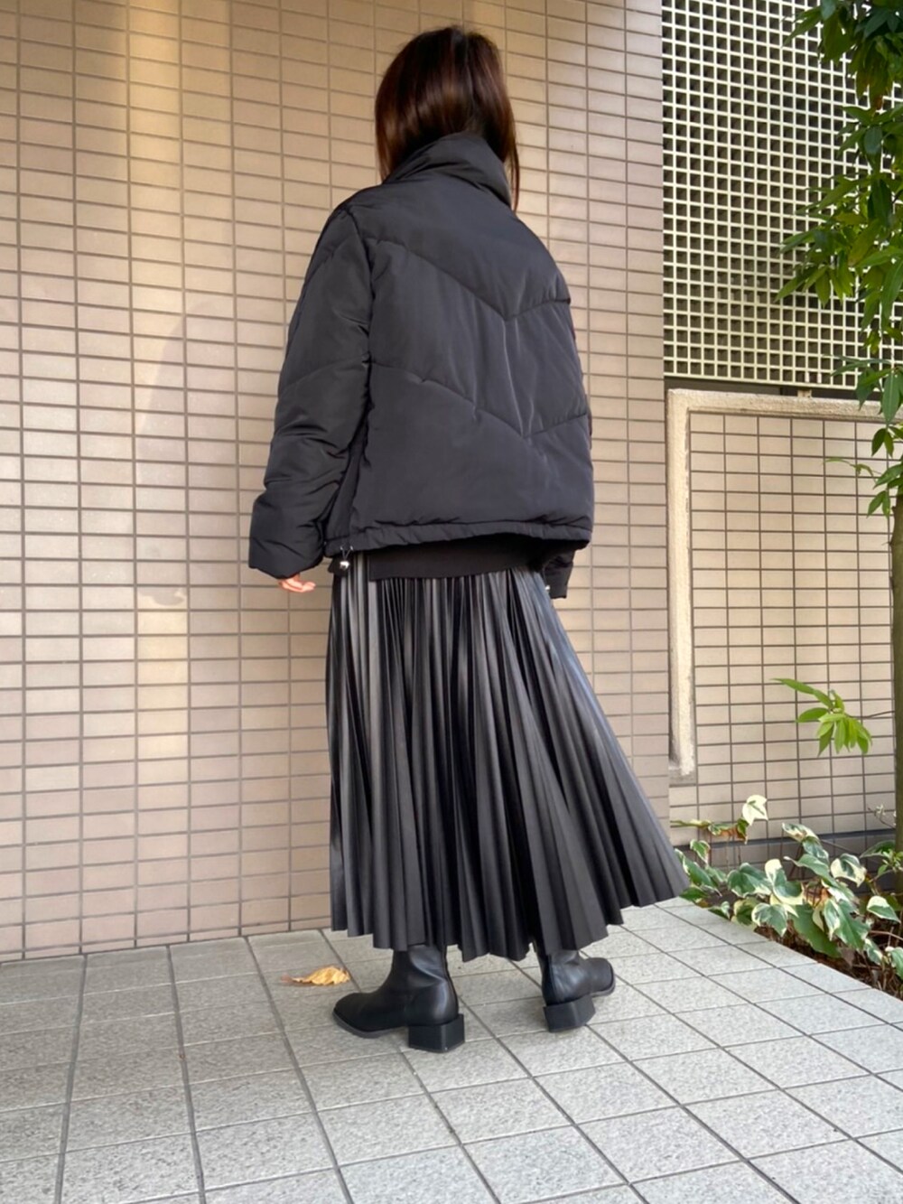 ブラック系のダウンジャケット/コート、ブラック系のスカート、ブラック系のブーツを着用したレディースの冬コーディネートの2枚目の写真