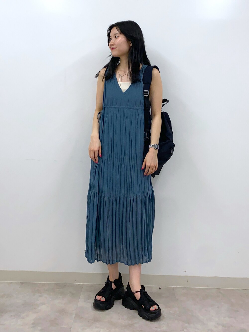 ブルー系のワンピース、ホワイト系のタンクトップ、ブラック系のショルダーバッグを着用したレディースの夏コーディネートの2枚目の写真