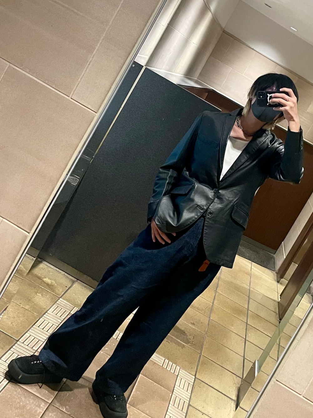 ブラック系のテーラードジャケット、ブルー系のデニムパンツ、ブラック系のその他シューズを着用したメンズの秋コーディネートの2枚目の写真