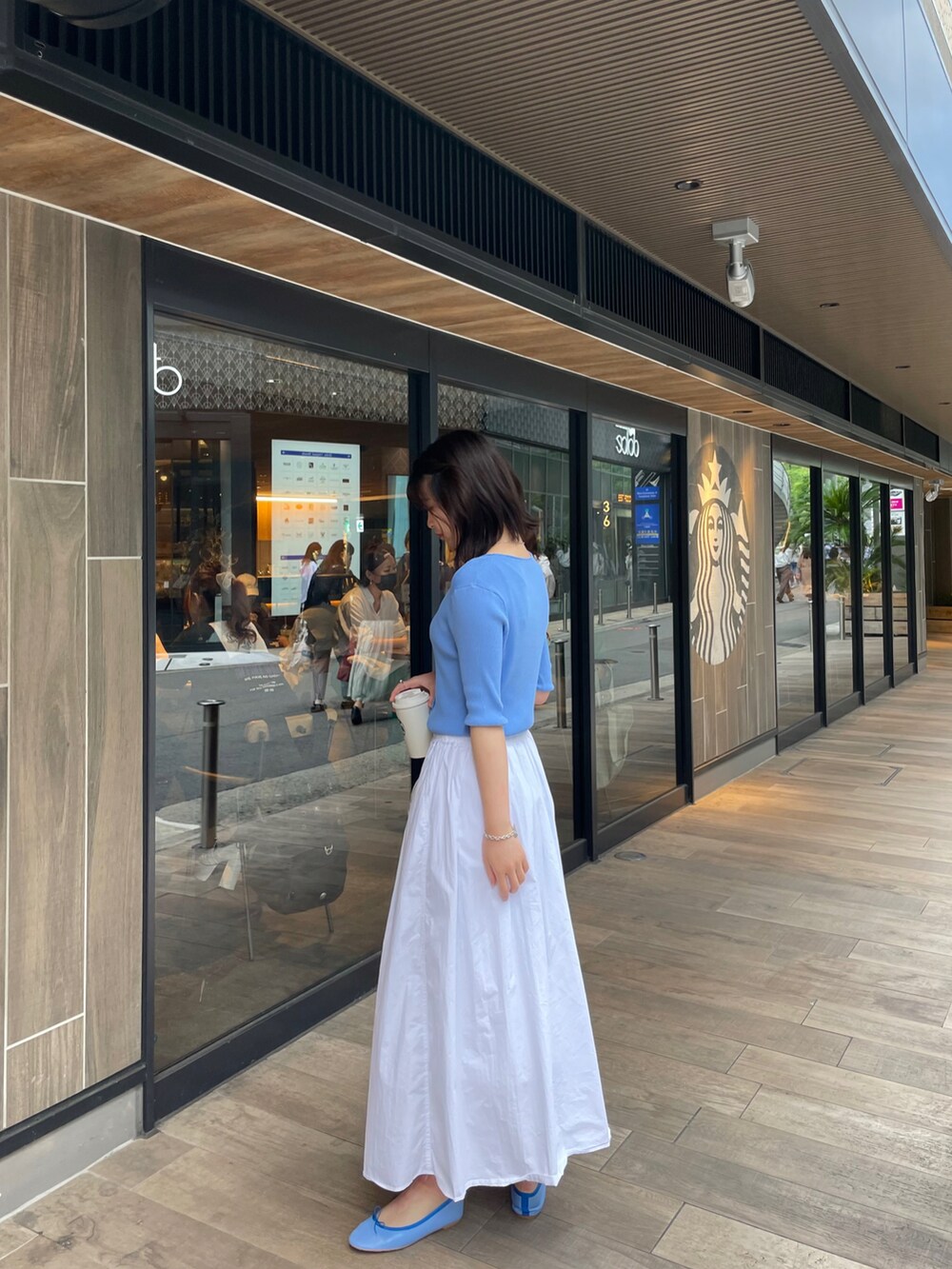 ブルー系のカーディガン/ボレロ、ホワイト系のスカート、ブルー系のバレエシューズを着用したレディースの夏コーディネートの2枚目の写真