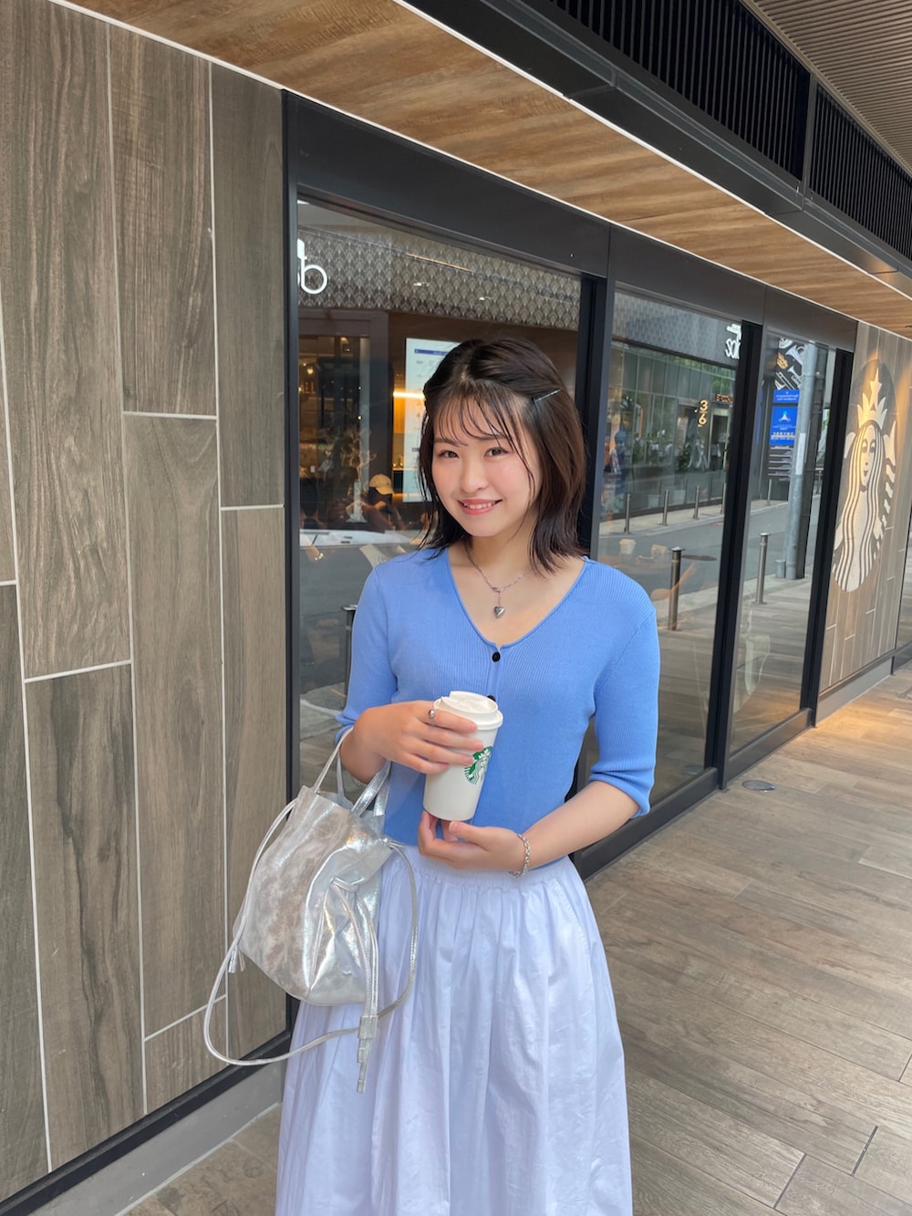 ブルー系のカーディガン/ボレロ、ホワイト系のスカート、ブルー系のバレエシューズを着用したレディースの夏コーディネートの3枚目の写真