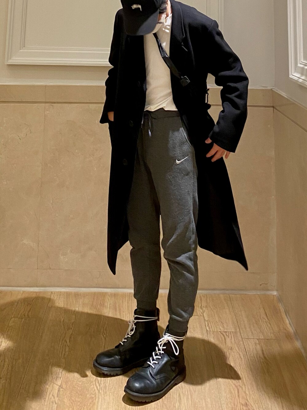 ブラック系のブーツ、グレー系のスラックス、ブラック系のトレンチコートを着用したメンズの冬コーディネートの2枚目の写真