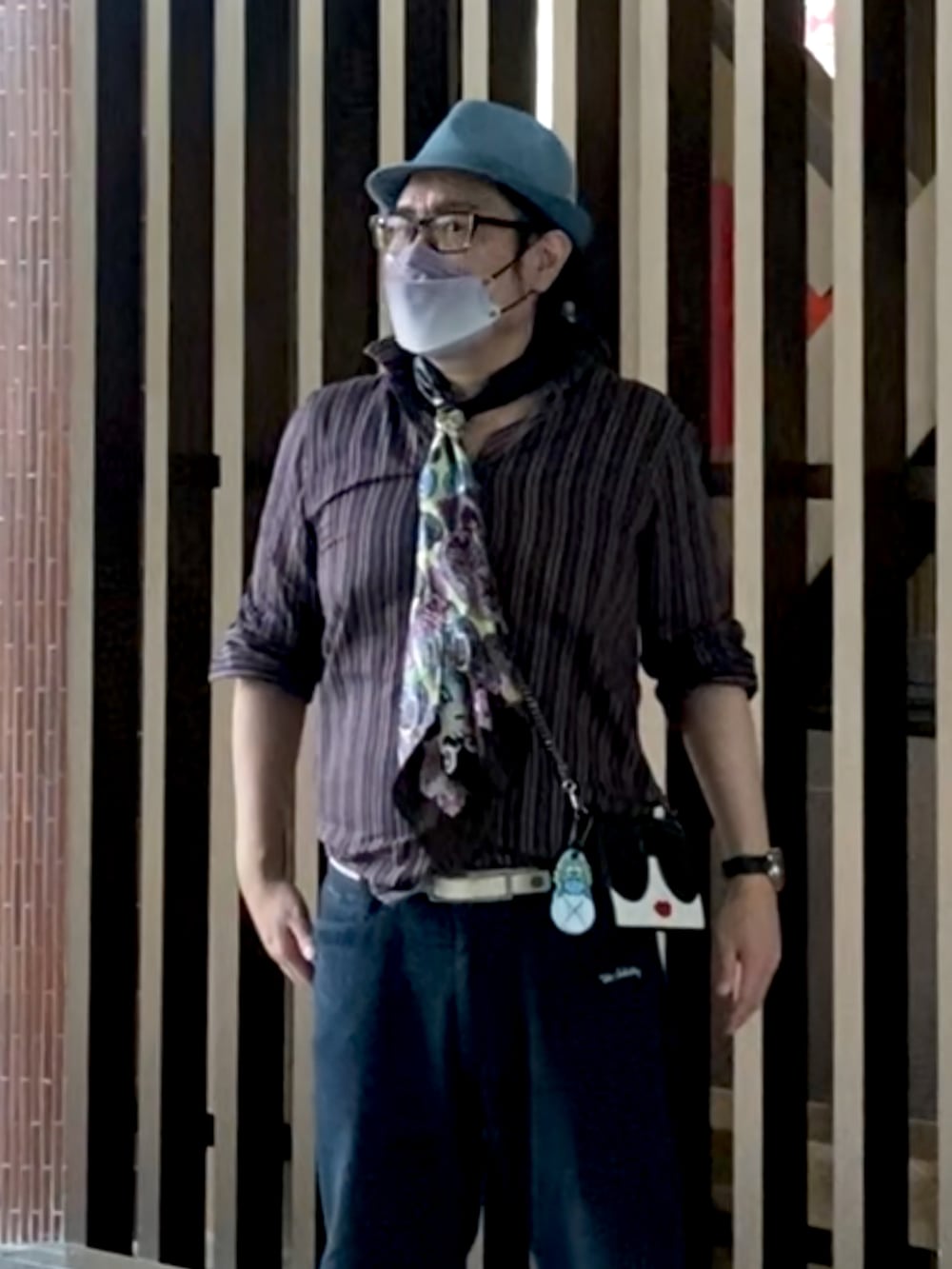 ブラック系のショルダーバッグ、ブラック系のシャツ/ブラウス、ベージュ系のブーツを着用したメンズの夏コーディネートの2枚目の写真