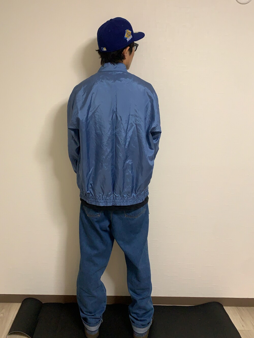 ブルー系のスニーカー、ブルー系のデニムパンツ、ブルー系のナイロンジャケットを着用したメンズの春コーディネートの2枚目の写真