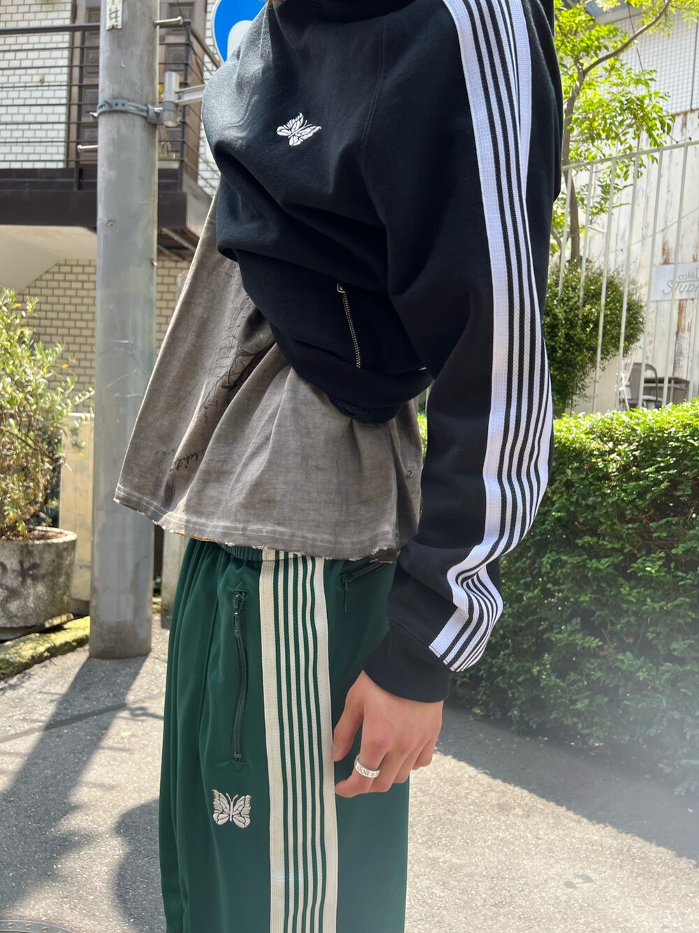 ブラック系のパーカー、グリーン系のパンツ、ベージュ系のTシャツ/カットソーを着用したメンズの夏コーディネートの4枚目の写真