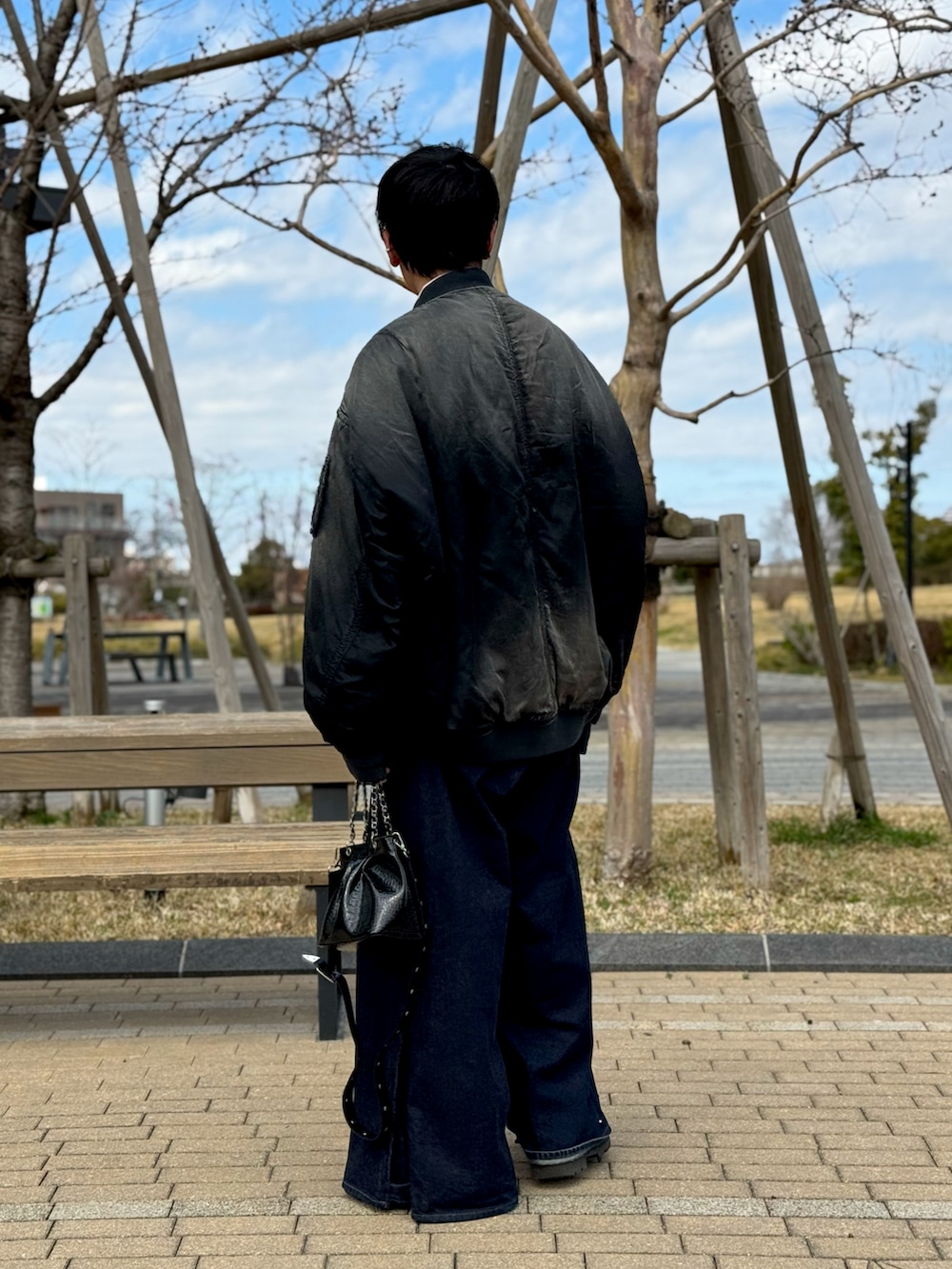 ブルー系のデニムパンツ、ブラック系のブルゾン、ピンク系のシャツ/ブラウスを着用したメンズの春コーディネートの2枚目の写真