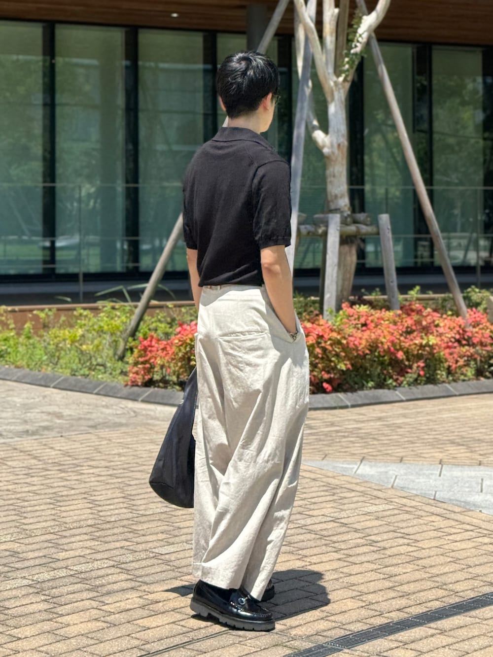 ホワイト系のその他パンツ、ブラック系のローファー、ブラック系のポロシャツを着用したメンズの夏コーディネートの3枚目の写真