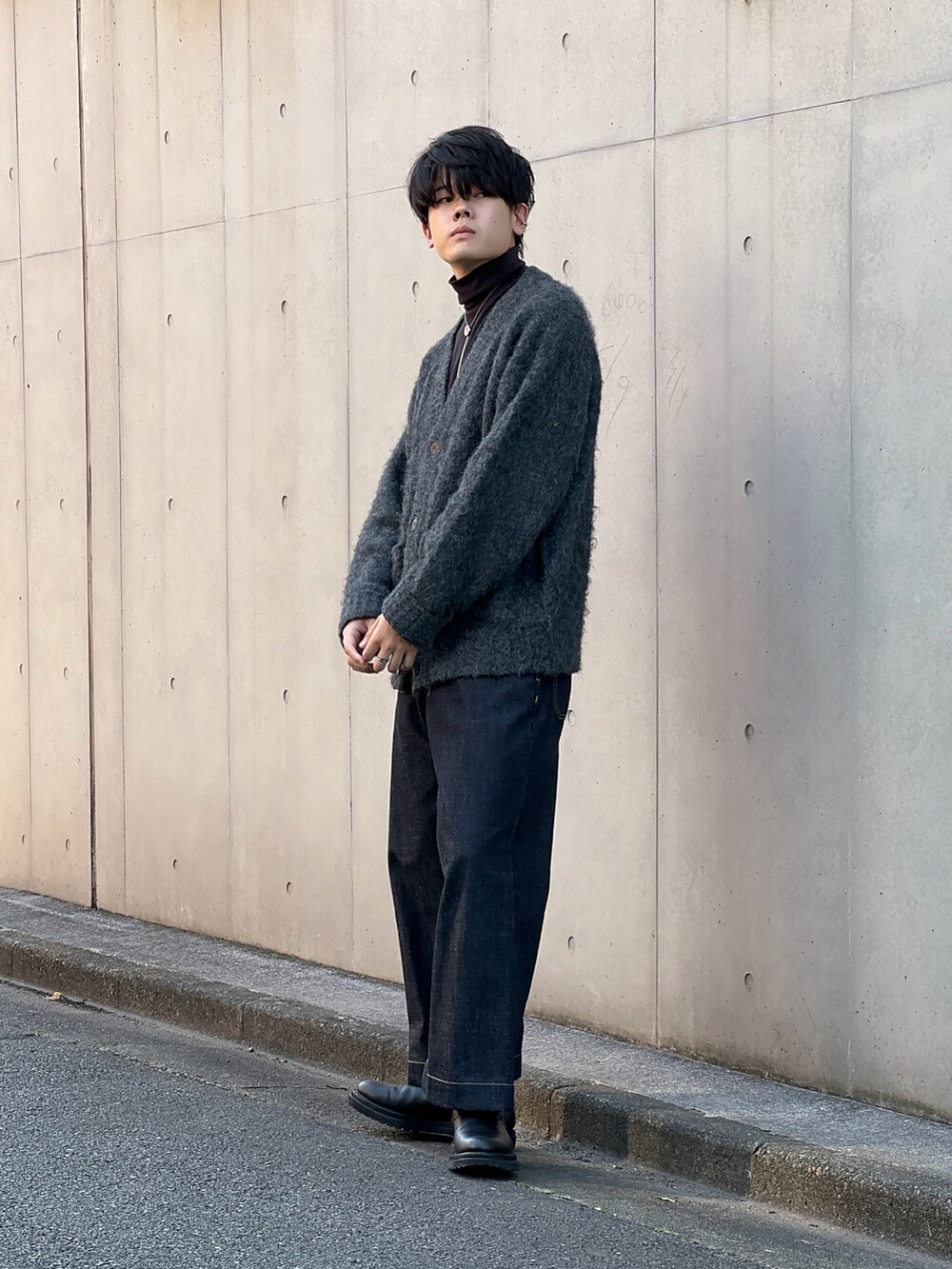 ブラック系のブーツ、ブルー系のデニムパンツ、グレー系のカーディガン/ボレロを着用したメンズの秋コーディネートの2枚目の写真