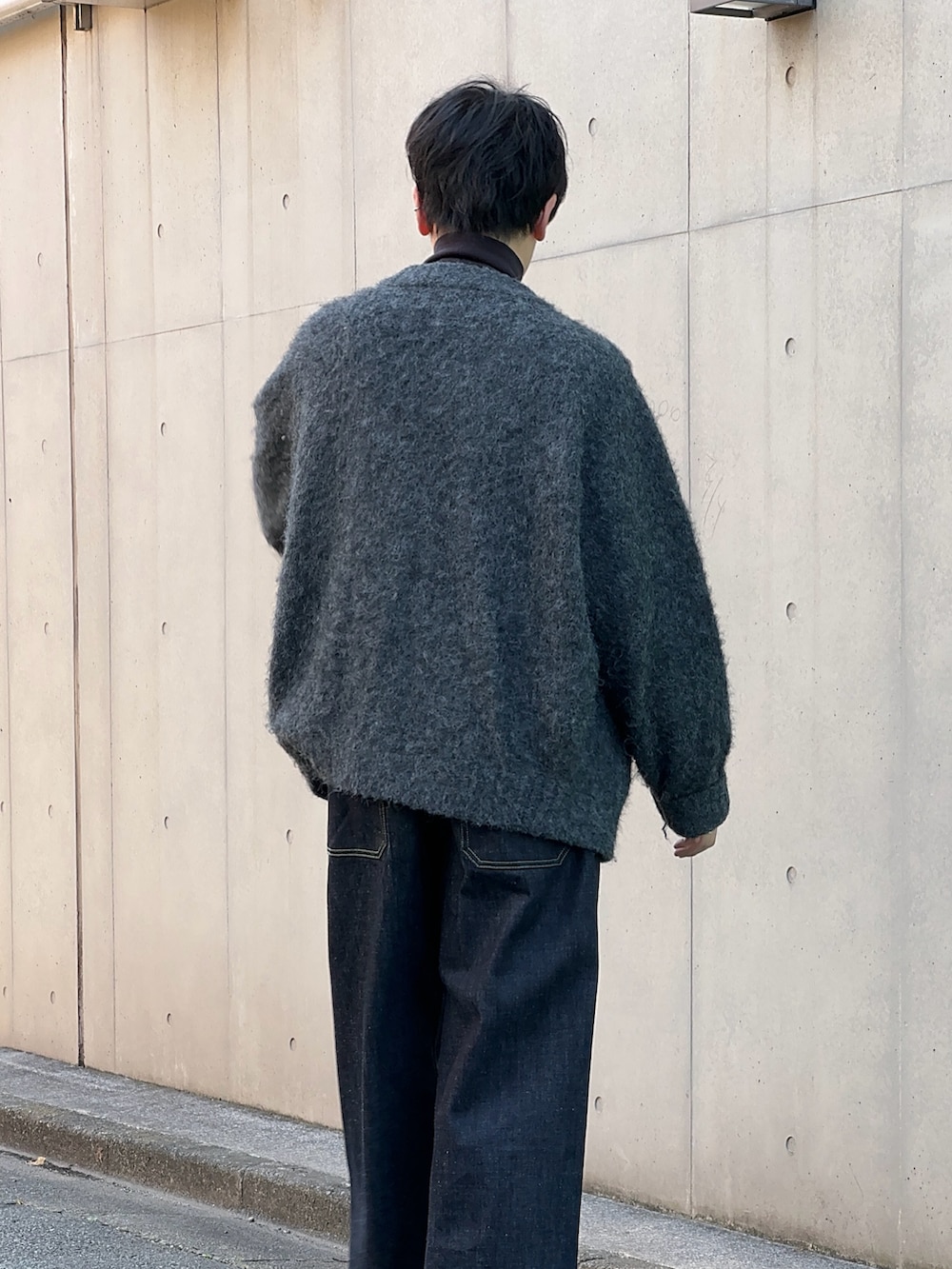 ブラック系のブーツ、ブルー系のデニムパンツ、グレー系のカーディガン/ボレロを着用したメンズの秋コーディネートの3枚目の写真