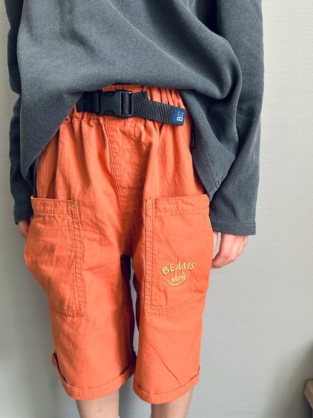 オレンジ系のその他パンツ、グレー系のTシャツ/カットソー、ホワイト系のスニーカーを着用したキッズの春コーディネートの5枚目の写真