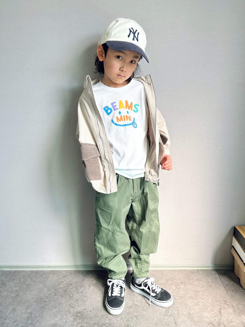 ホワイト系のTシャツ/カットソー、グリーン系のデニムパンツ、ブラック系のスニーカーを着用したキッズの春コーディネートの2枚目の写真