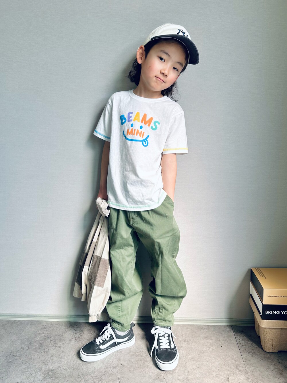 ホワイト系のTシャツ/カットソー、グリーン系のデニムパンツ、ブラック系のスニーカーを着用したキッズの春コーディネートの5枚目の写真