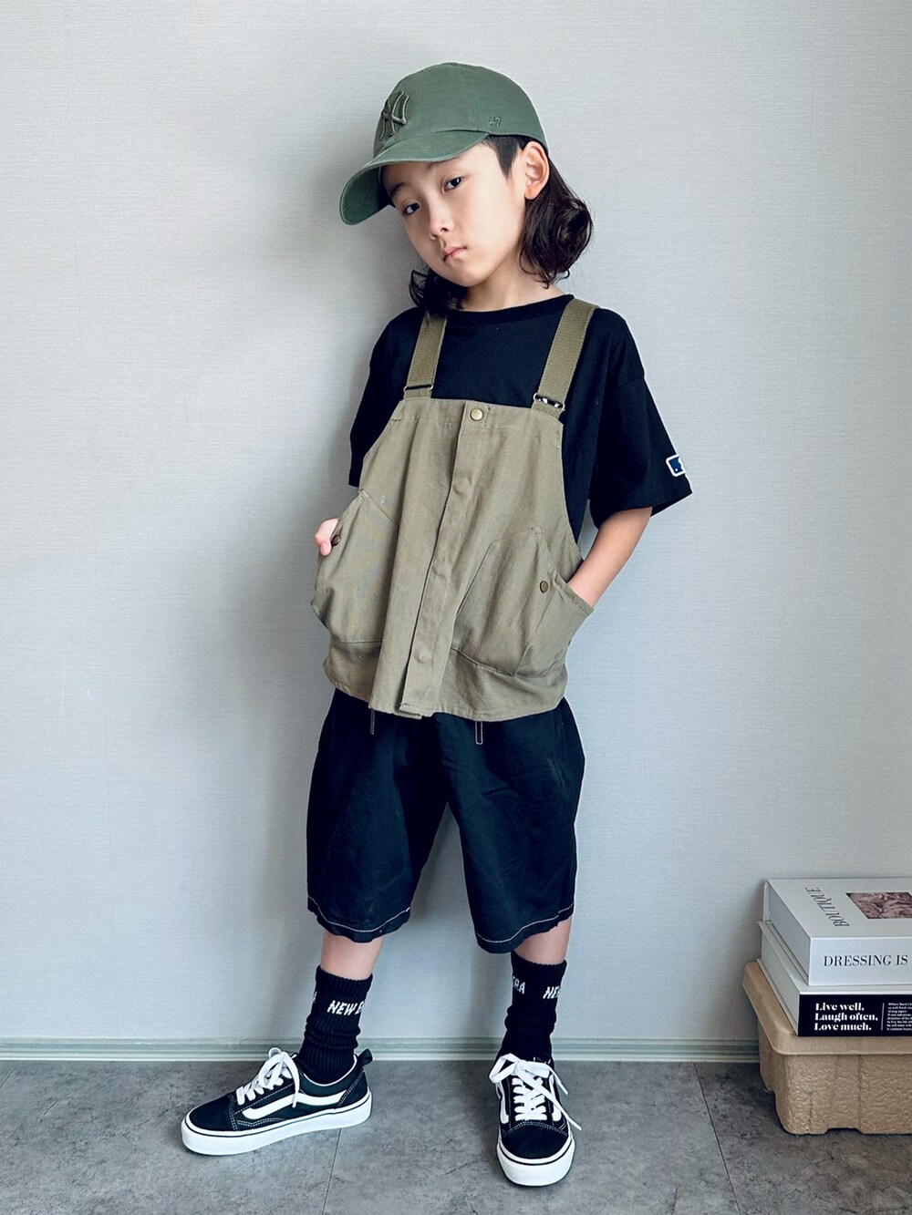 グリーン系のベスト、ブラック系のスニーカー、グリーン系のキャップを着用したキッズの夏コーディネートの2枚目の写真
