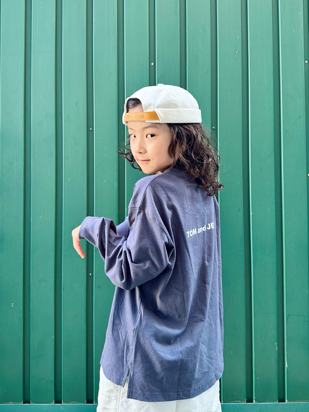 グレー系のTシャツ/カットソー、ホワイト系のパンツ、ホワイト系のスニーカーを着用したキッズの秋コーディネートの3枚目の写真