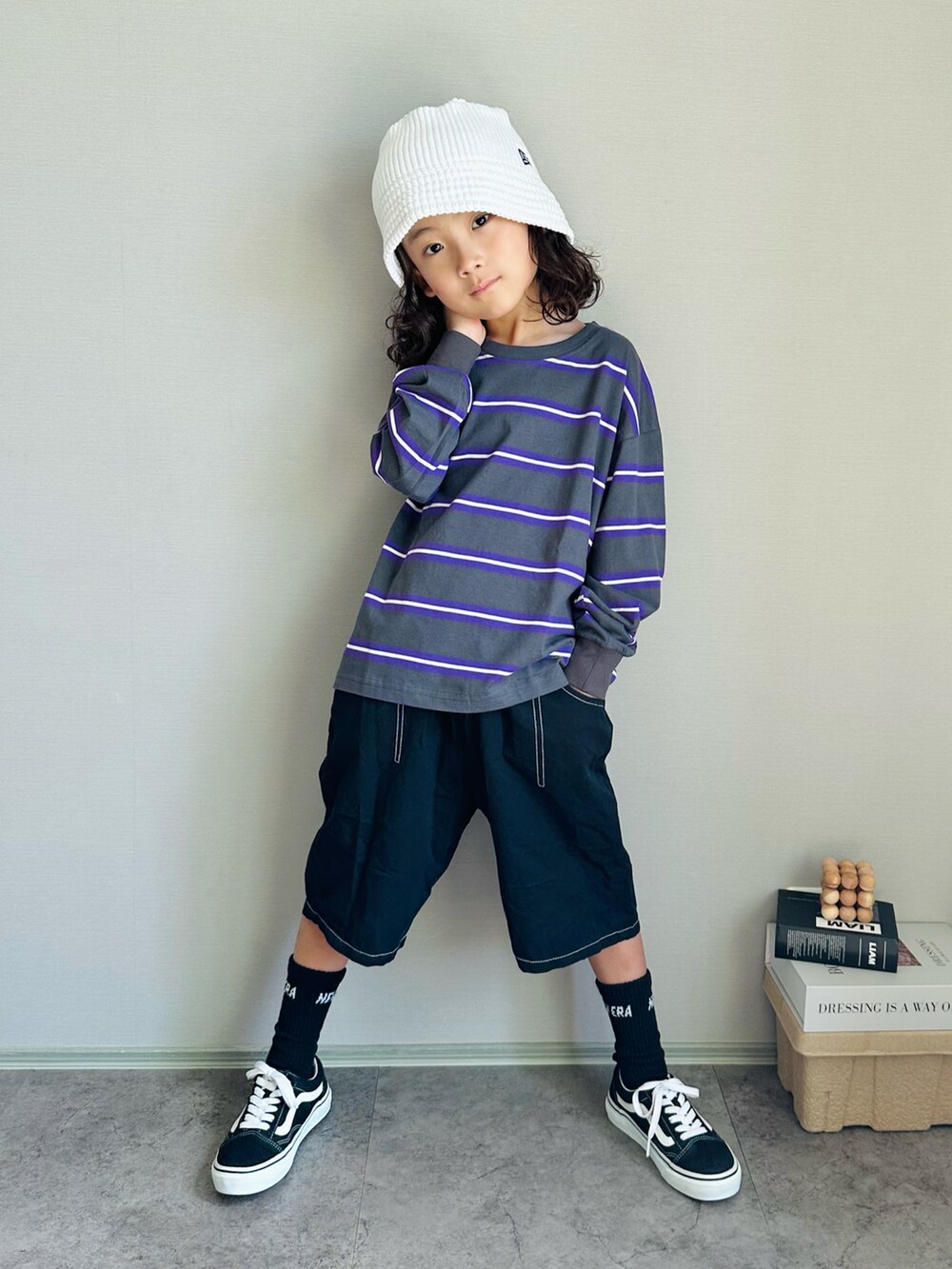 グレー系のTシャツ/カットソー、ブラック系のスニーカー、ホワイト系のハットを着用したキッズの秋コーディネートの2枚目の写真