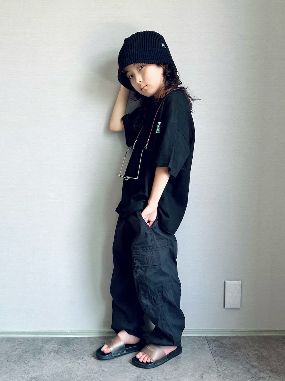 ブラック系のTシャツ/カットソー、ブラック系のパンツ、ブラック系のサンダルを着用したキッズの夏コーディネートの2枚目の写真