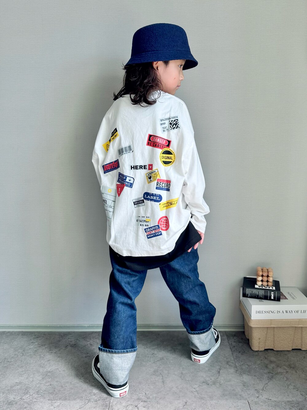 ホワイト系のTシャツ/カットソー、ブラック系のスニーカー、ブルー系のデニムパンツを着用したキッズの秋コーディネートの2枚目の写真