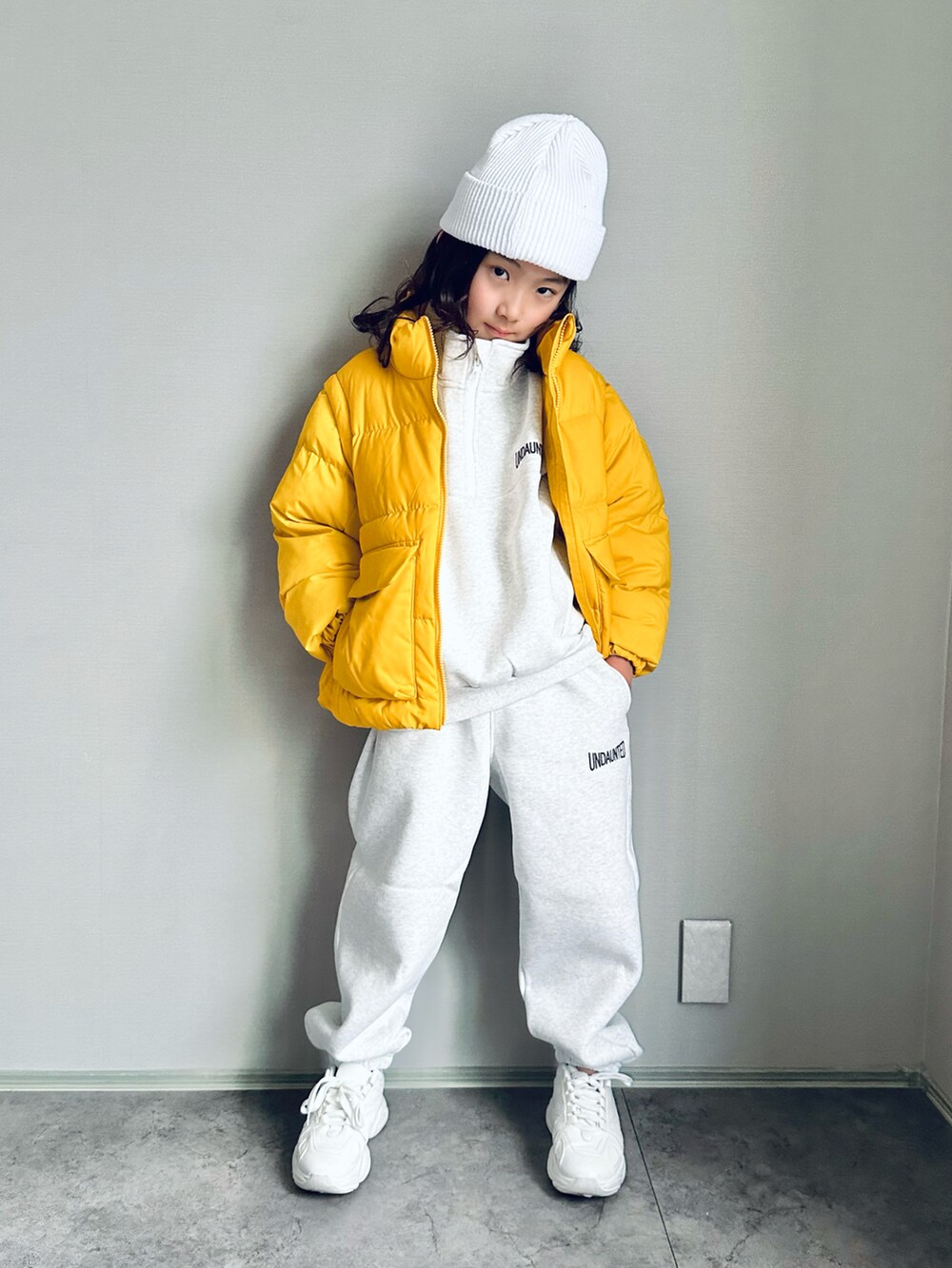 イエロー系のジャケット/アウター、ホワイト系のトップス、ホワイト系のスウェットパンツを着用したキッズの冬コーディネートの2枚目の写真