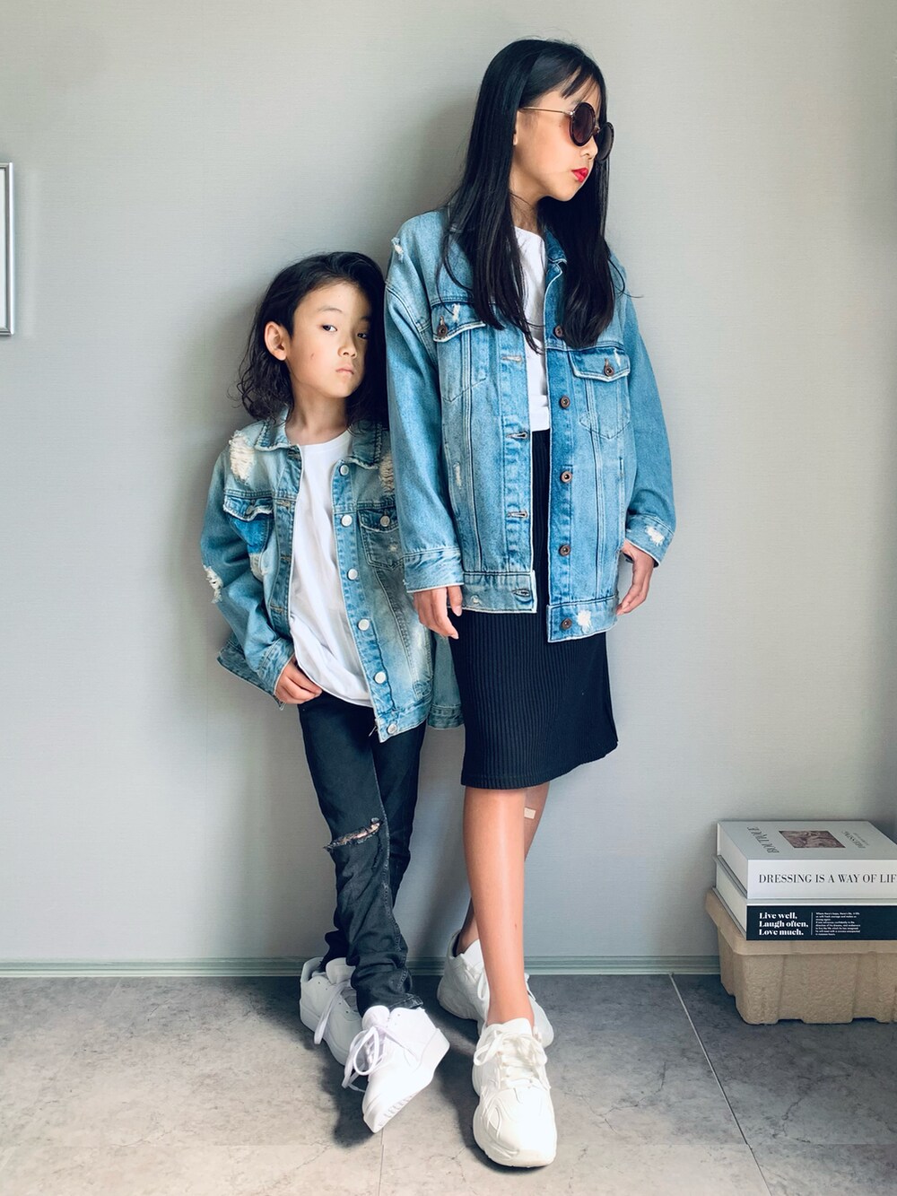 ホワイト系のスニーカー、ブルー系のデニムジャケット、ブルー系のデニムジャケットを着用したキッズの秋コーディネートの2枚目の写真