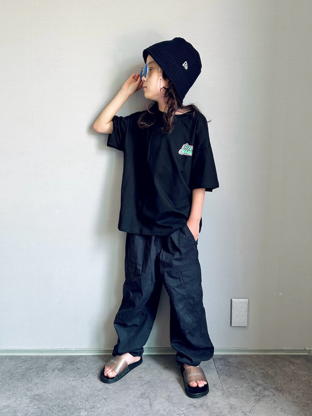 ブラック系のTシャツ/カットソー、ブラック系のパンツ、ブラック系のサンダルを着用したキッズの夏コーディネートの3枚目の写真