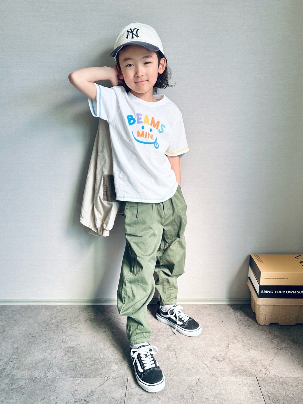 ホワイト系のTシャツ/カットソー、グリーン系のデニムパンツ、ブラック系のスニーカーを着用したキッズの春コーディネートの3枚目の写真